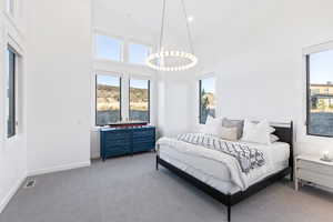 Carpeted bedroom featuring a high ceiling and recessed lighting