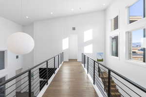 Hallway featuring dark wood finished floors, an upstairs landing, recessed lighting, and vaulted ceiling