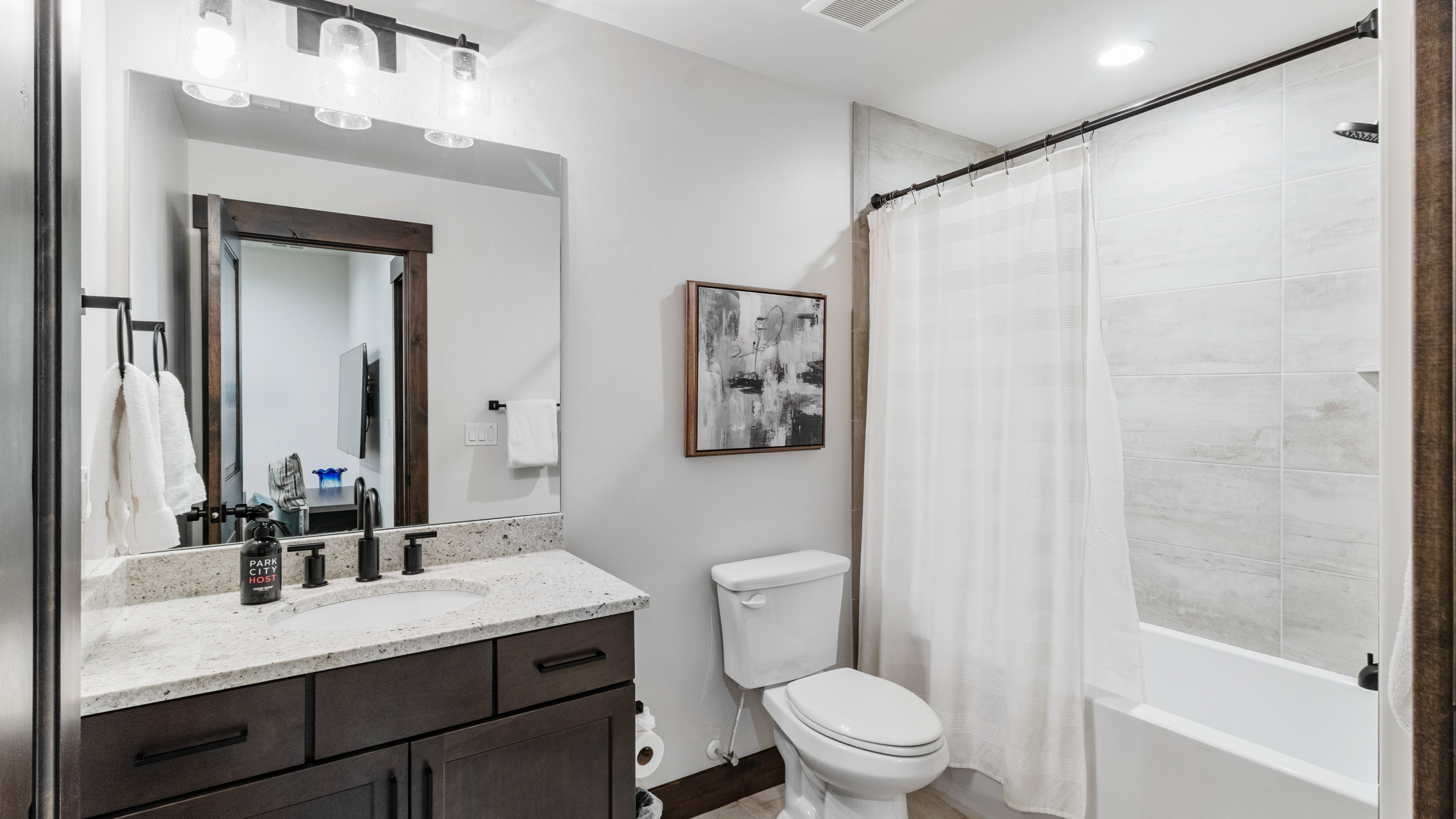 Bathroom featuring vanity, shower / tub combo with curtain, and recessed lighting