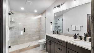 Bathroom with double vanity, a stall shower, and recessed lighting