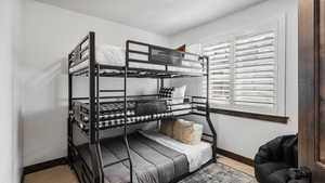 Bedroom featuring light carpet and baseboards