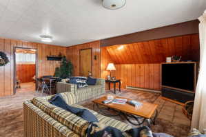 Living room featuring wood walls and baseboard heating