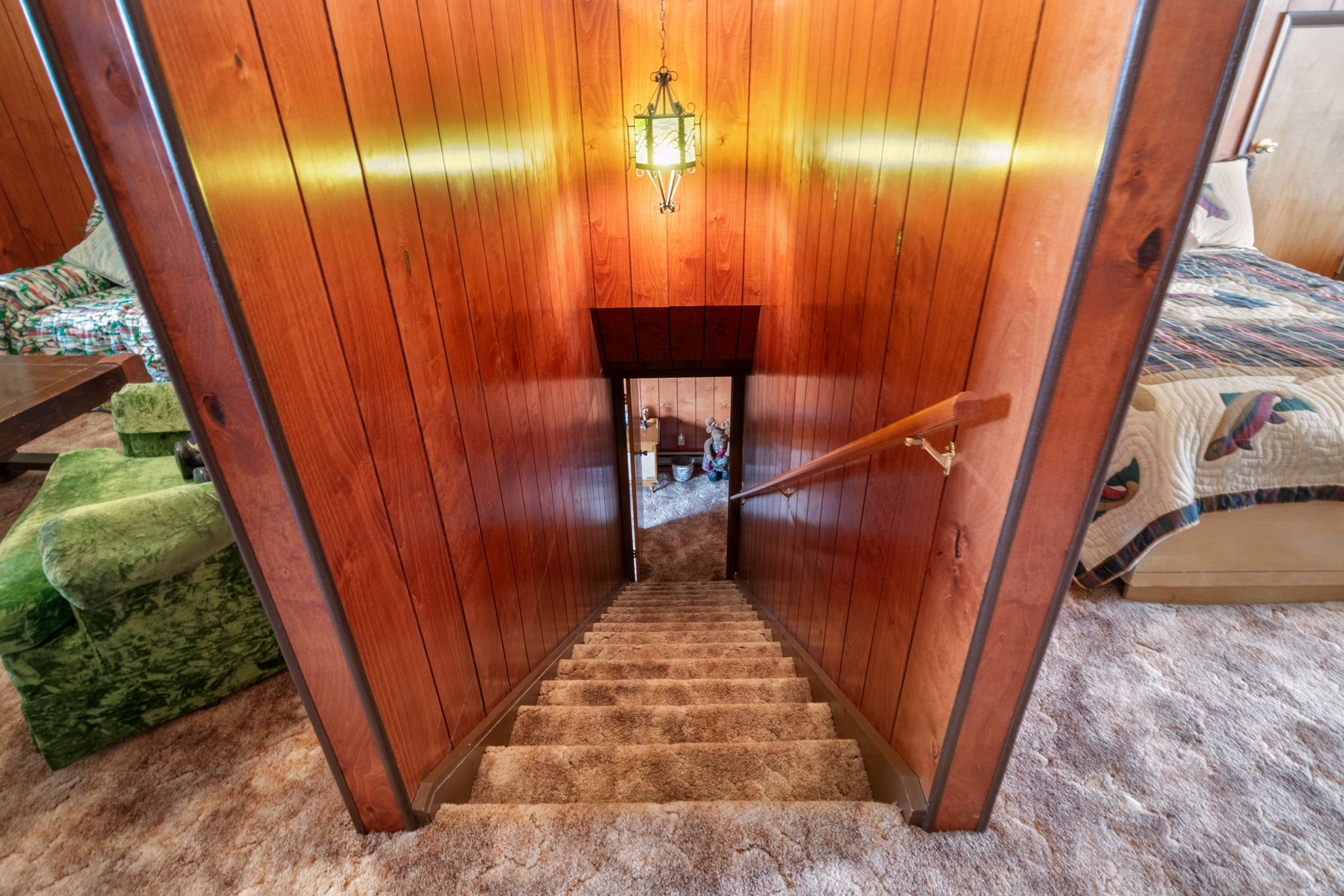 Staircase with carpet floors and wooden walls