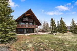 Back of house featuring a patio area, a yard, and board and batten siding
