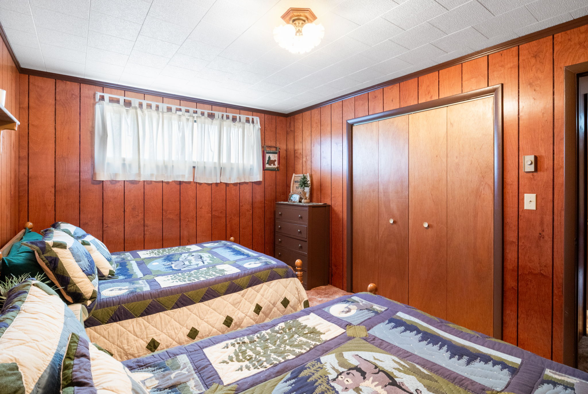 Bedroom with a closet and wood walls