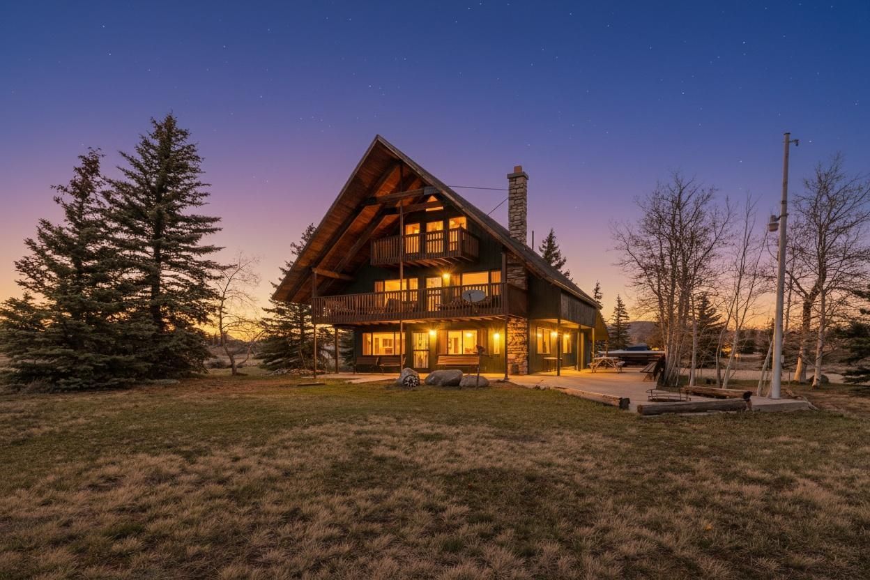 Back of property at dusk featuring a yard, a chimney, and a patio area