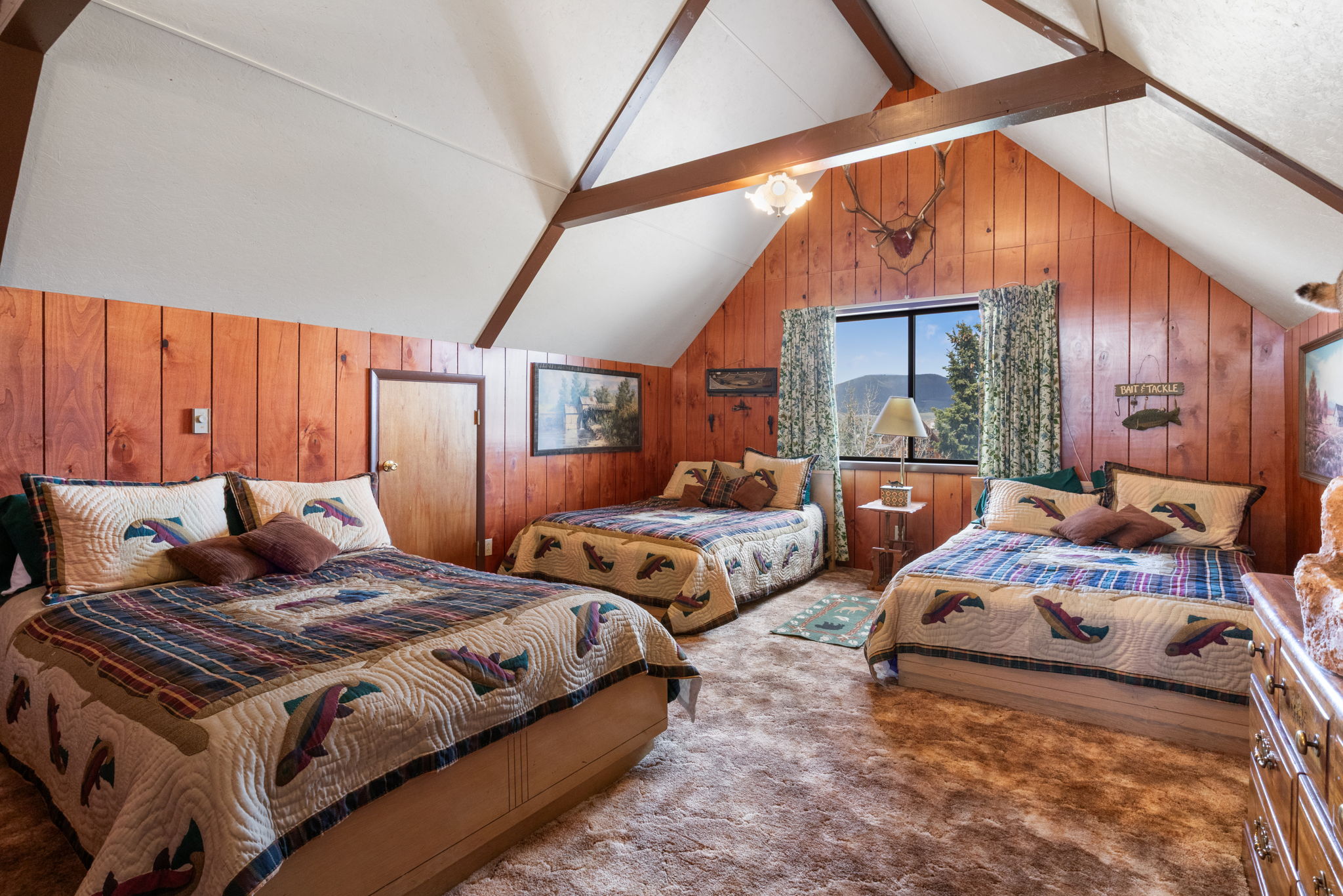 Bedroom with beam ceiling, wood walls, and carpet flooring