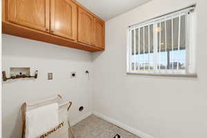Laundry area featuring hookup for a washing machine, hookup for an electric dryer, and cabinet space