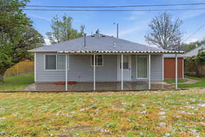 Back of house with roof with shingles and a patio