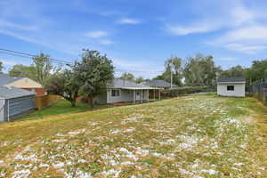 Rear view of house with a fenced backyard, a patio, and a storage shed