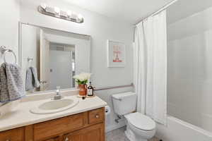 Bathroom with vanity, shower / tub combo, and light tile patterned floors