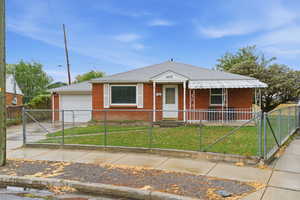 Bungalow-style house with a gate, a fenced front yard, brick, a porch, and driveway