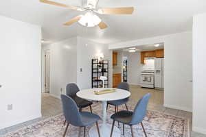 Dining space with ceiling fan and light tile patterned flooring