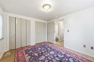 Bedroom featuring multiple closets and light wood LVP