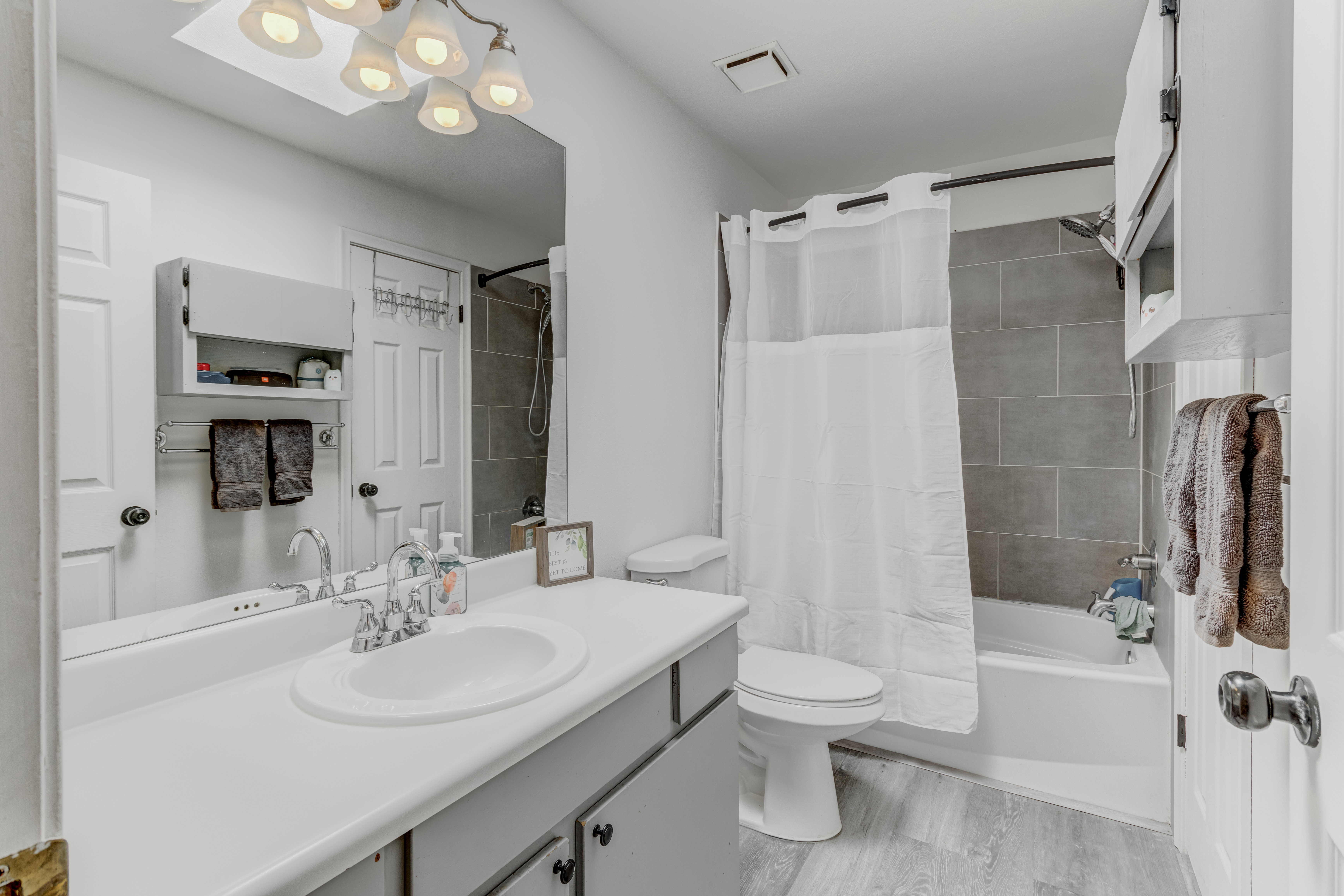 Full bathroom featuring vanity, shower / bath combo, and light wood finished floors