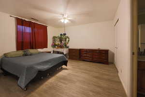 Bedroom with wood finished floors, ceiling fan, a closet, and a textured ceiling
