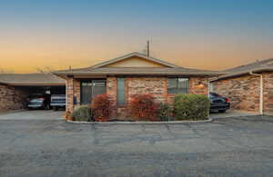 Single story home featuring brick siding, an attached carport, and roof with shingles
