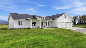 Modern inspired farmhouse featuring covered porch, roof with shingles, driveway, and board and batten siding