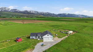Aerial view of sparsely populated area featuring agricultural land and a mountainous background