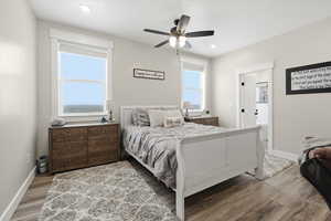 Bedroom with light wood-style floors, ceiling fan, and recessed lighting