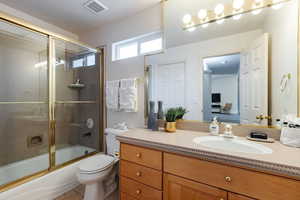 Bathroom featuring vanity, enclosed tub / shower combo, and light tile patterned floors