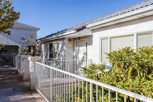 Doorway to property with stucco siding and a tile roof