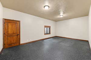 Unfurnished room with a textured ceiling