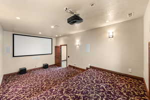 Cinema room featuring dark carpet and recessed lighting