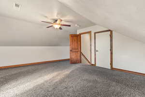 Bonus room with lofted ceiling, a ceiling fan, and carpet floors