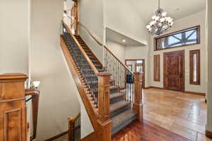 Entryway featuring a high ceiling, stone tile flooring, and suspended lighting