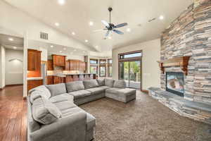 Living room with ceiling fan, a fireplace, recessed lighting, arched walkways, and lofted ceiling
