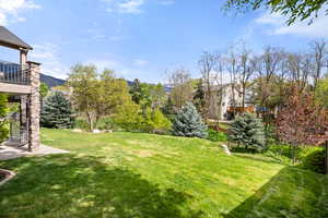 View of green lawn featuring a balcony