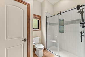 Bathroom with a stall shower and light wood-style flooring
