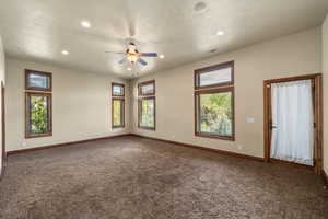 Carpeted spare room featuring ceiling fan and recessed lighting