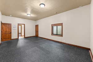 Unfurnished room with baseboards and a textured ceiling