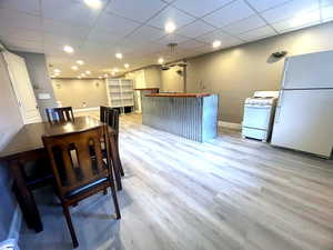 Kitchen featuring white appliances, a drop ceiling, light wood finished floors, recessed lighting, and wood counters
