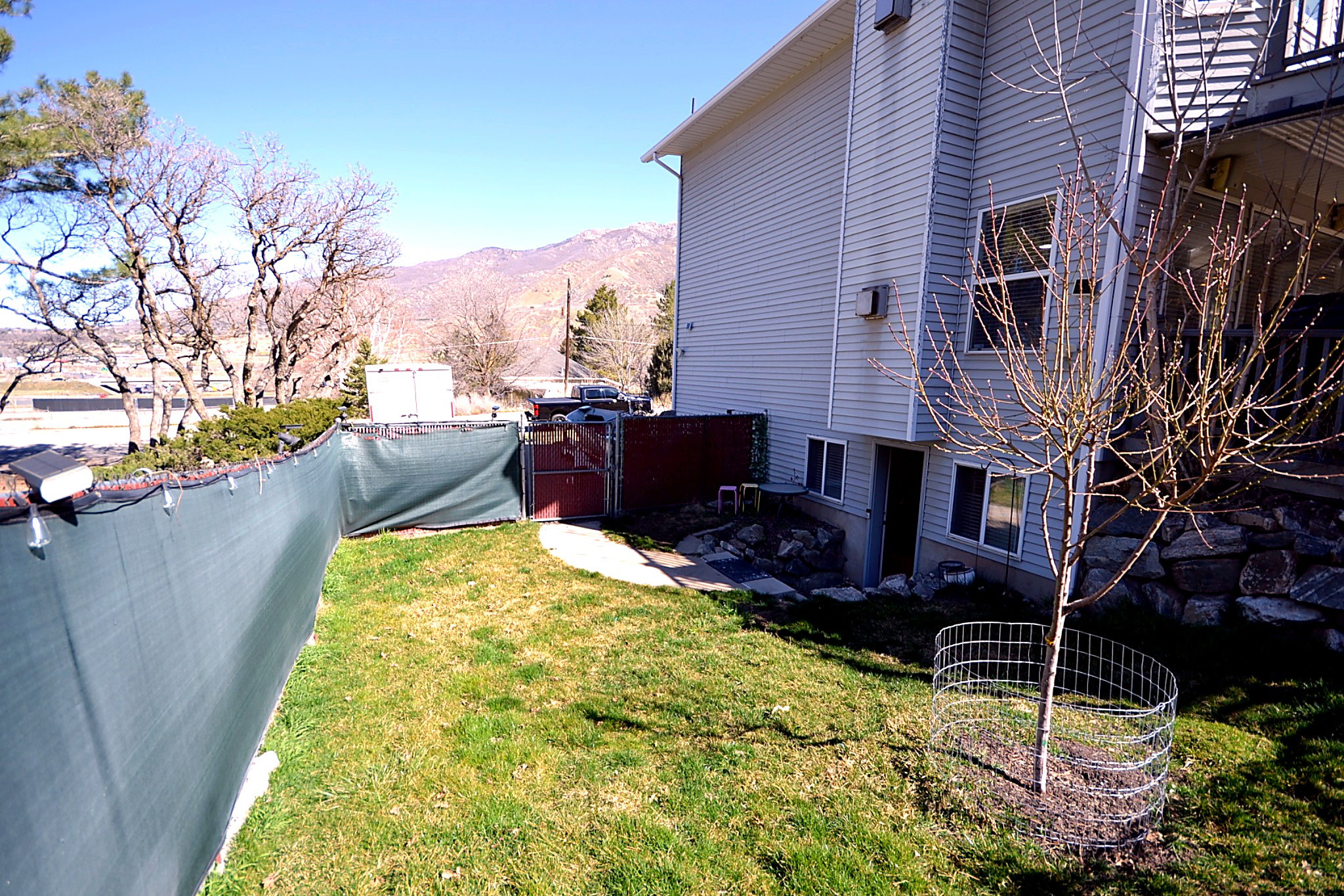 View of property exterior with a mountain view, a gate, and a fenced backyard