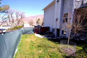 View of property exterior with a mountain view, a gate, and a fenced backyard