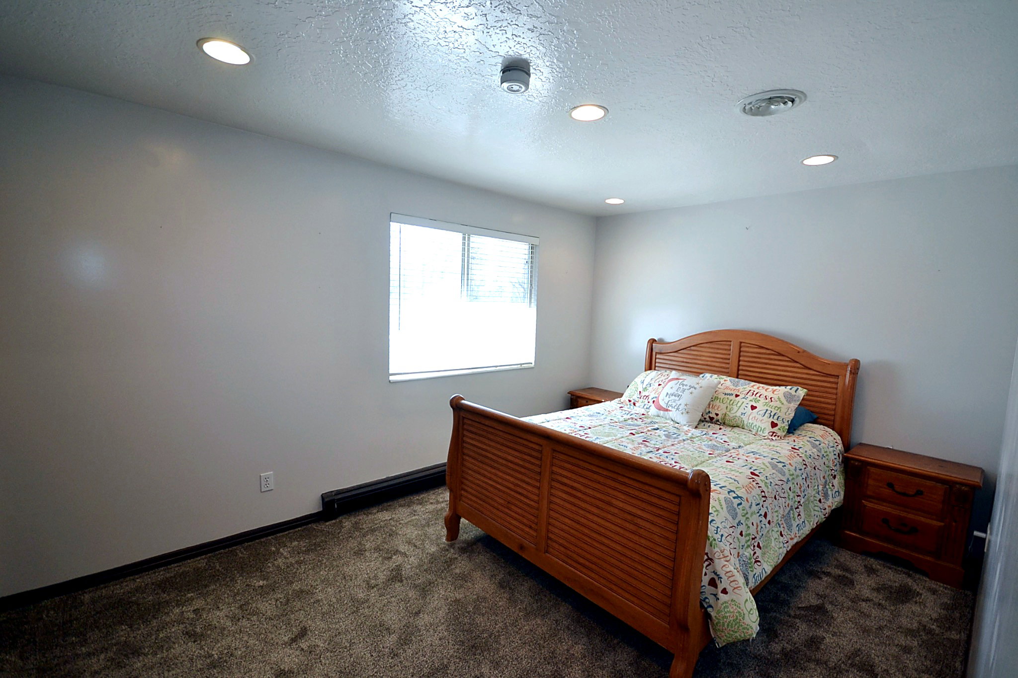 Bedroom featuring a textured ceiling, dark carpet, and recessed lighting