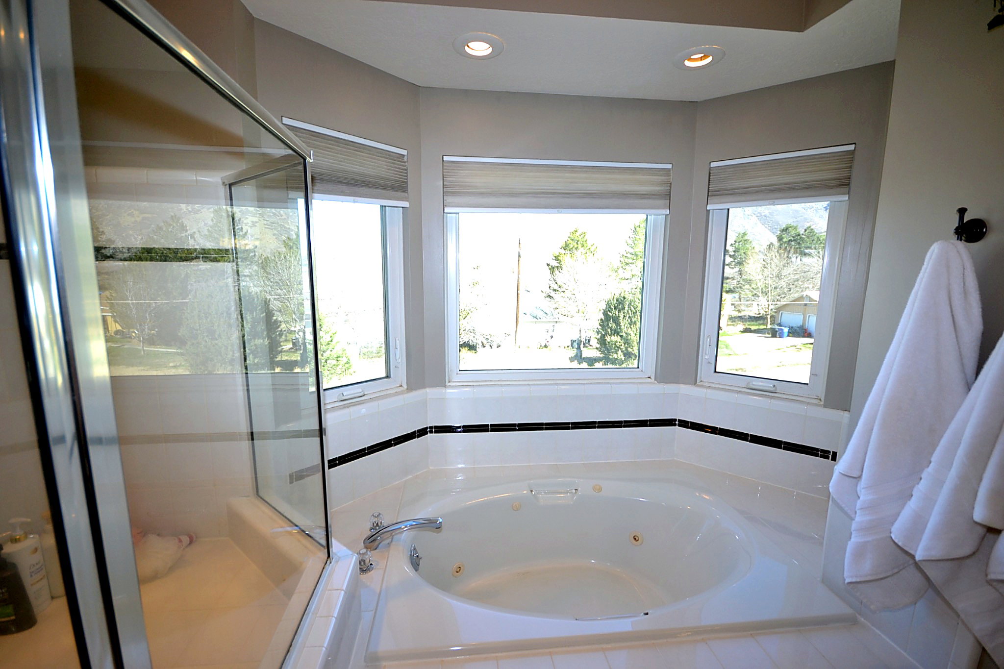 Bathroom with a shower stall, a tub with jets, and recessed lighting