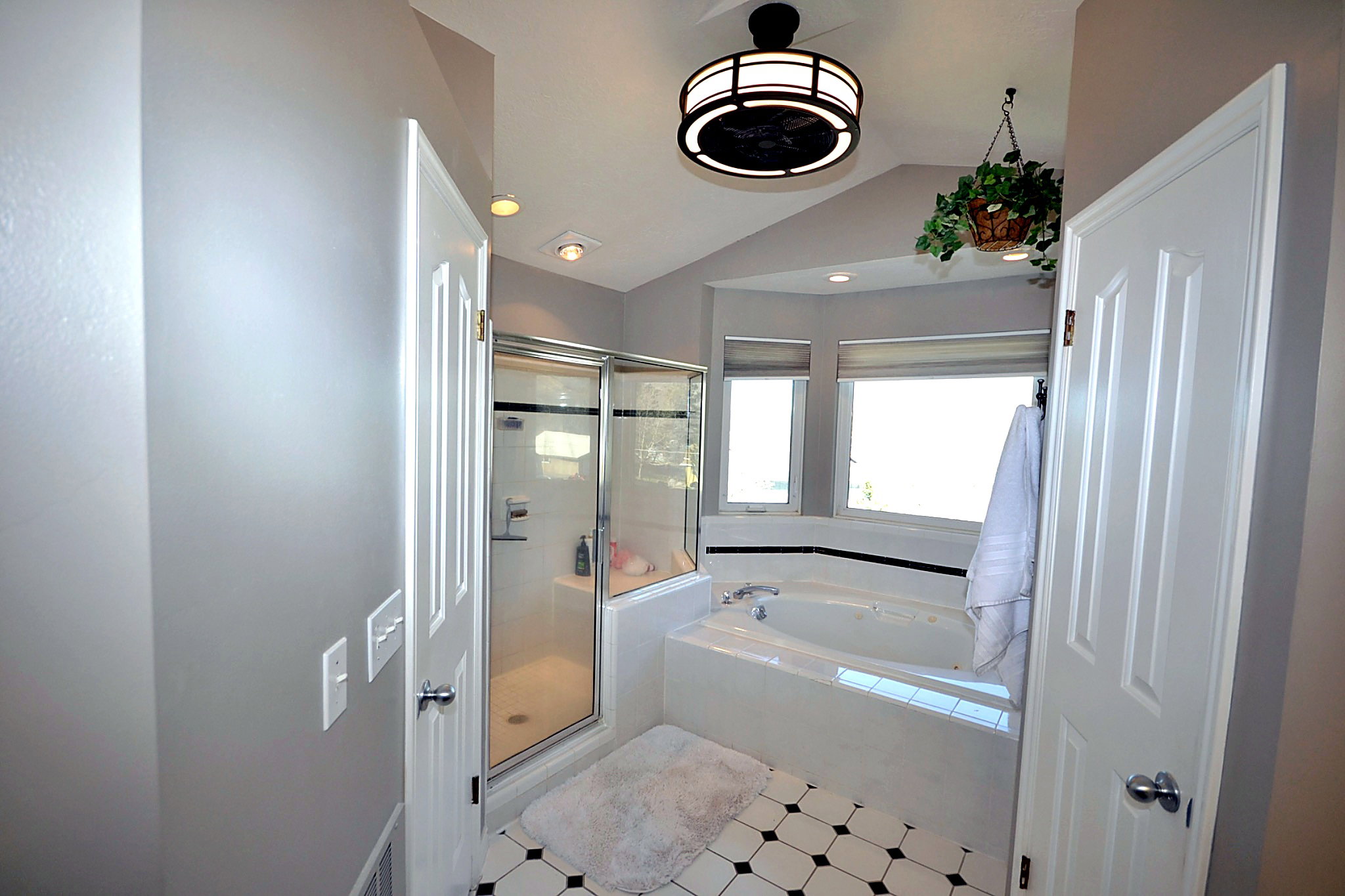 Bathroom featuring a stall shower, vaulted ceiling, a garden tub, and recessed lighting