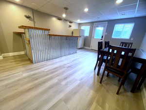 Dining room with a paneled ceiling, light wood-style floors, and recessed lighting