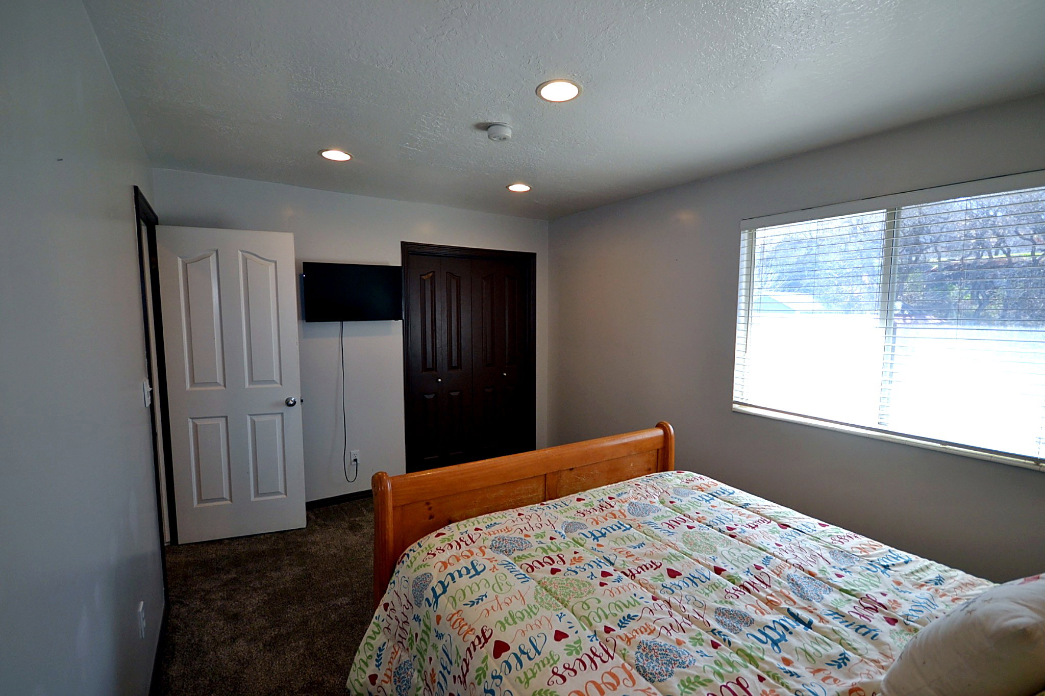 Bedroom featuring dark carpet, a textured ceiling, recessed lighting, and a closet