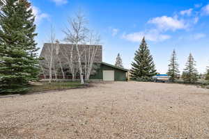 View of front of house with a chimney, driveway, and a garage
