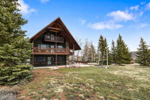 Back of house featuring a patio area, a yard, and board and batten siding
