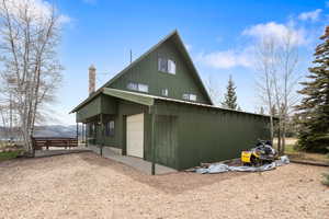 View of home's exterior with a chimney and driveway