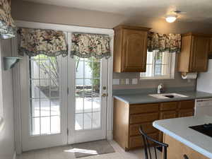 Kitchen featuring wood finish cabinets, dishwasher, and light tile patterned floors