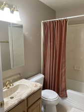 Bathroom with vanity, shower / bath combo with shower curtain, and tile patterned floors