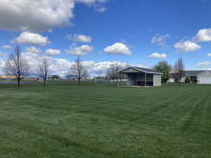 View of grassy yard featuring a patio