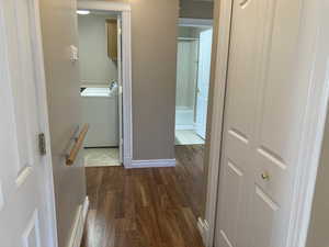 Hallway with washer / dryer and dark wood-style flooring